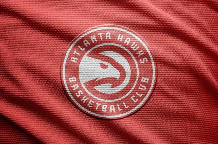 Free basketball logo mockup with a textured jersey background and realistic embroidered effect on fabric.