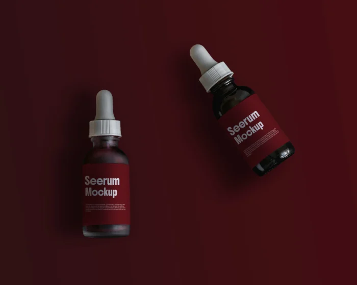Two serum bottle mockups with brown labels on a dark brown background, featuring editable shadows and realistic details.